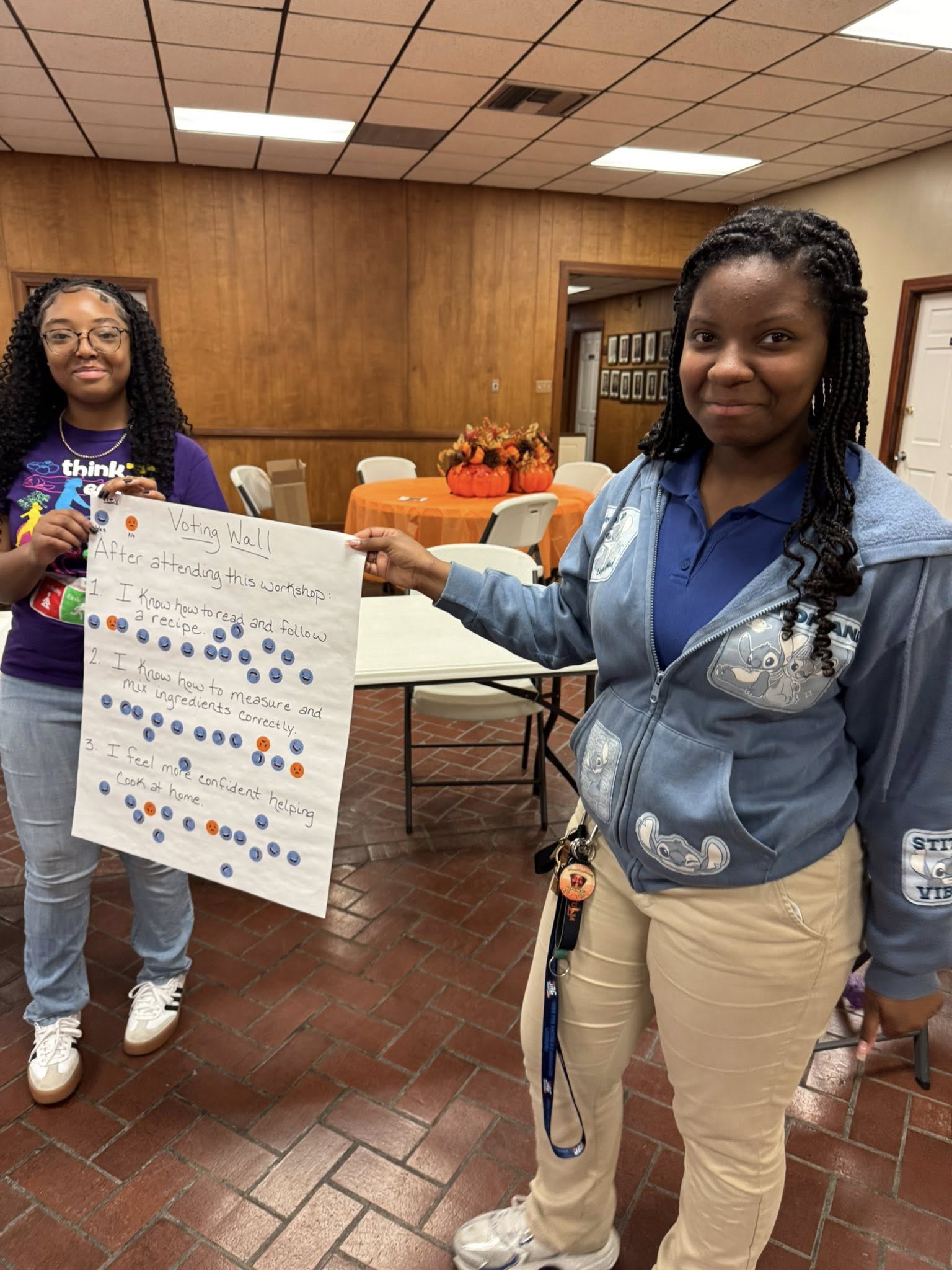 Two girls holding a poster.